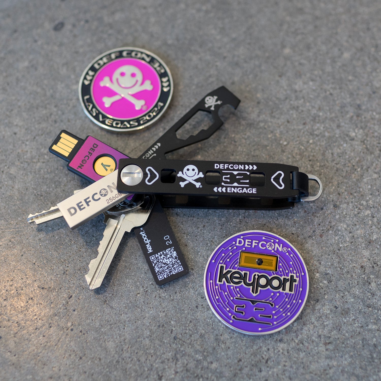 Keyport at DEF CON 32 with the DC32 Pivot 2.0, DC32 MOCA Too, DC32 YubiStyle covered YubiKey, and DC32 challenge coin